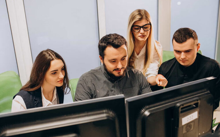 team looking at computer monitor