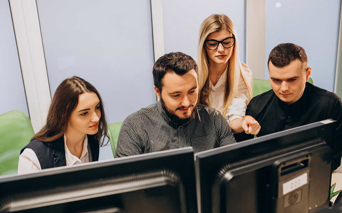 team looking at computer monitor