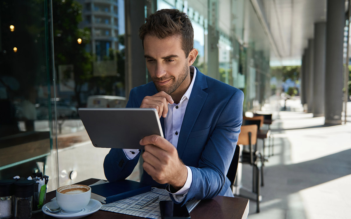 businessman looking at his tablet at a coffee shop