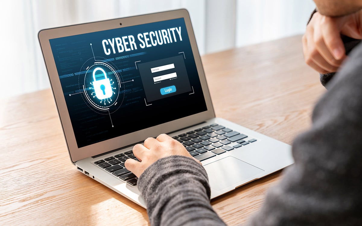 man woking on his laptop at the office with cyber security alert